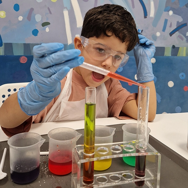 Warsztaty dla przedszkoli Biały Bór – dzieci w fartuchach wykonują chemiczne eksperymenty