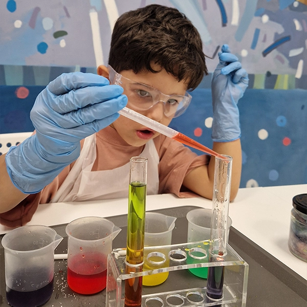 Warsztaty dla przedszkoli Unisław – dzieci w fartuchach wykonują eksperyment chemiczny