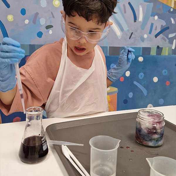 Warsztaty dla przedszkoli Wałcz – dzieci w fartuchach wykonują bezpieczne eksperymenty chemiczne